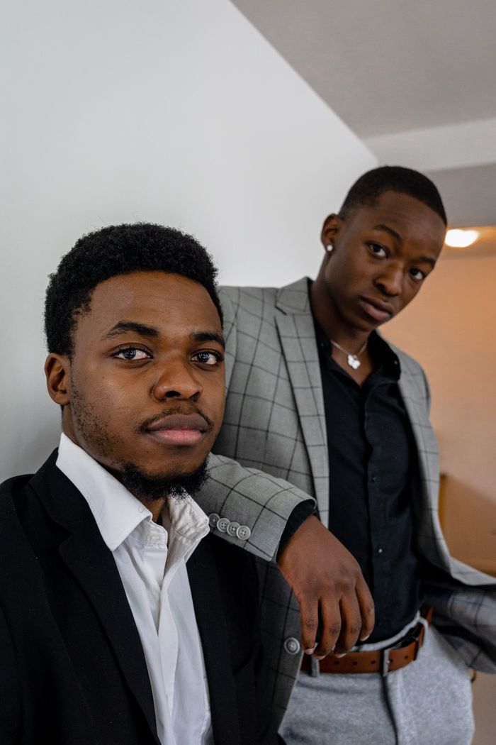gallery-04 Two young men in fashionable blazers posing confidently indoors, expressing style and elegance.